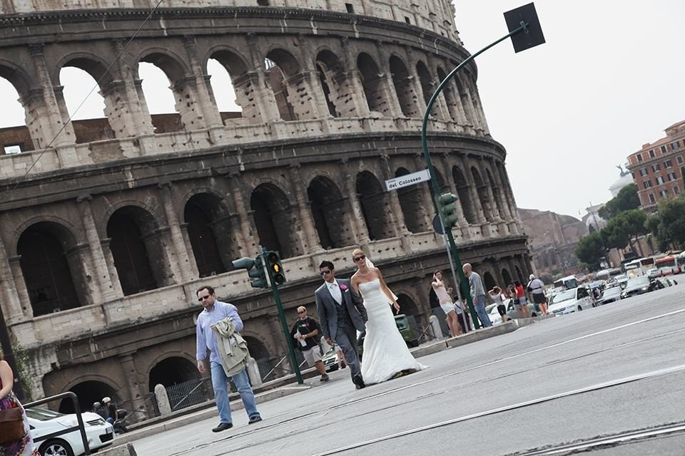 een bruid en bruidegom lopen op straat voor het Colosseum