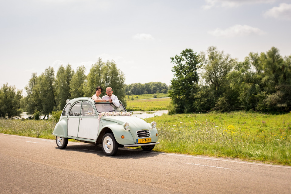 een paar rijdt in een kleine auto op de weg