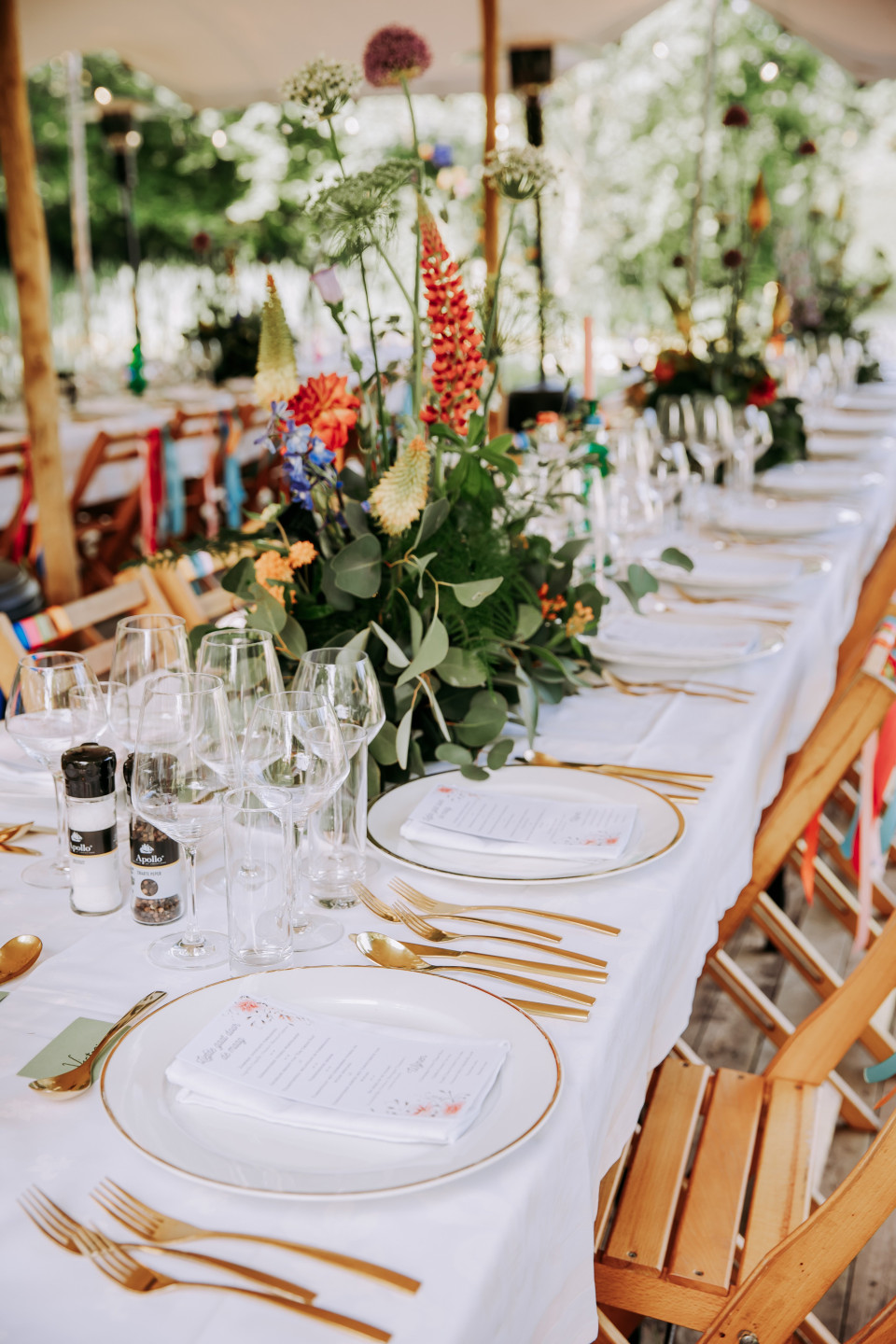 Kleurrijke tafeldecoratie met bloemen en gekleurde linten