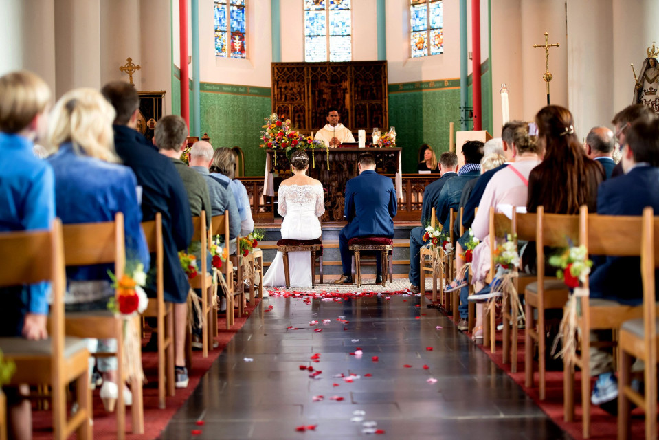 een trouwceremonie in een kerk met mensen die op stoelen zitten