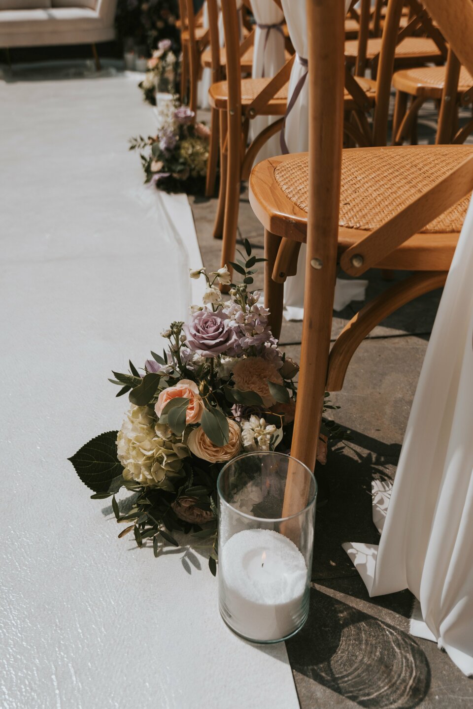 een rij stoelen met bloemen en een kaars op de grond