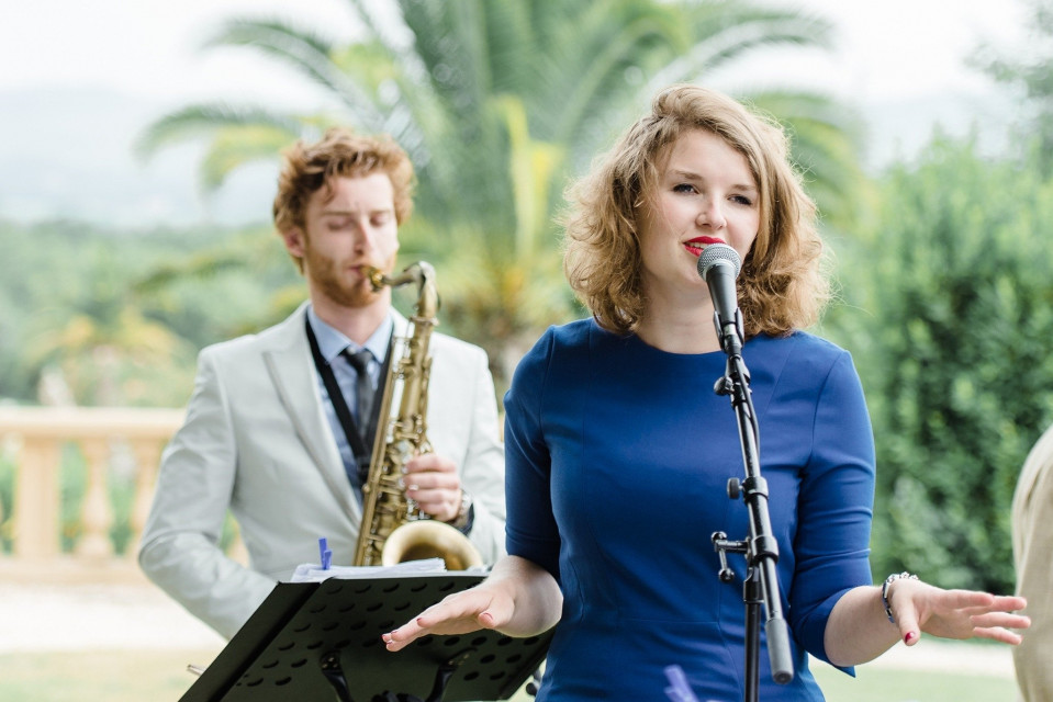 een vrouw in een blauwe jurk die in een microfoon zingt