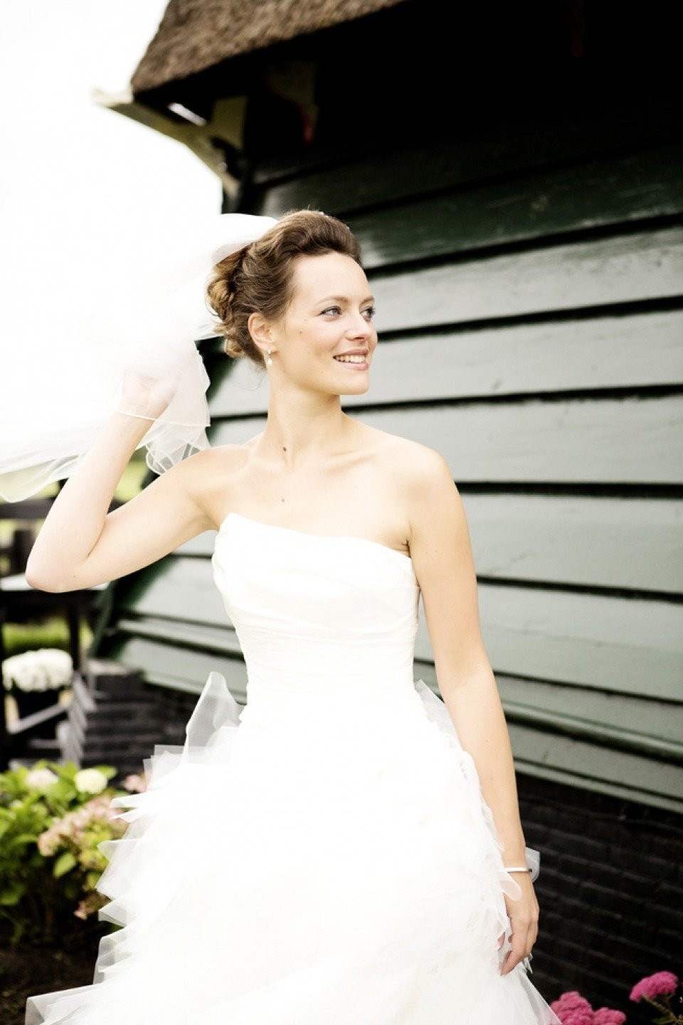 een bruid in een witte trouwjurk die buiten staat