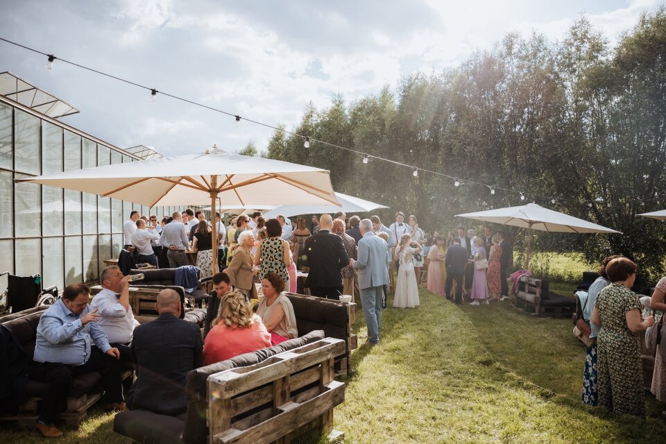een grote groep mensen die onder parasols zit