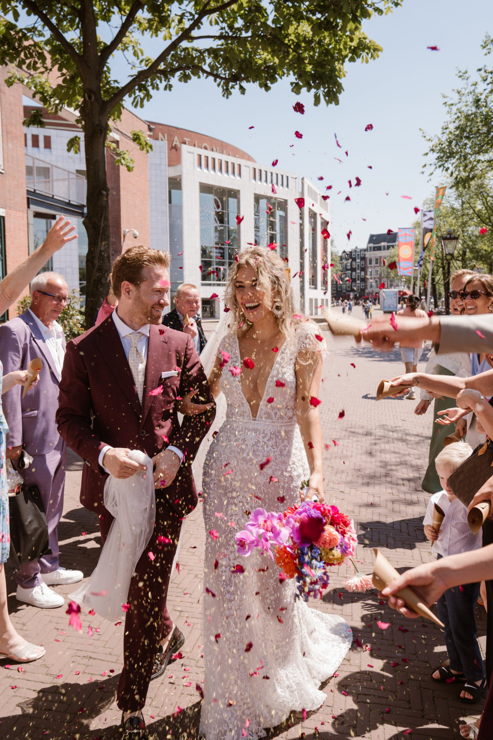 een bruid en bruidegom worden met confetti overgoten door hun gasten