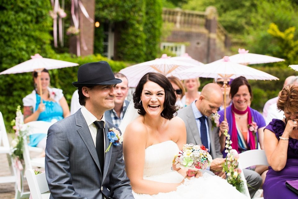 een bruidspaar zit voor hun gasten