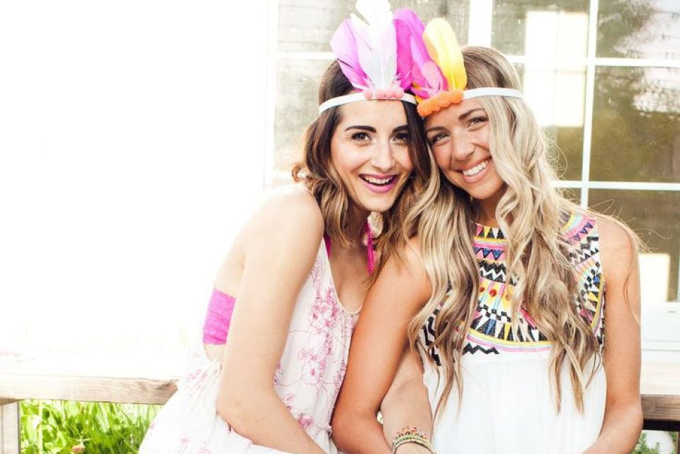 twee vrouwen met kleurrijke hoofddeksels die elkaars hand vasthouden