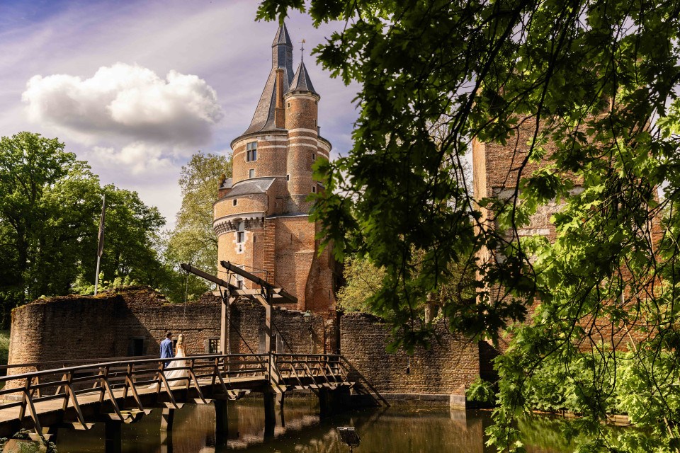 een brug over een rivier met een toren op de achtergrond