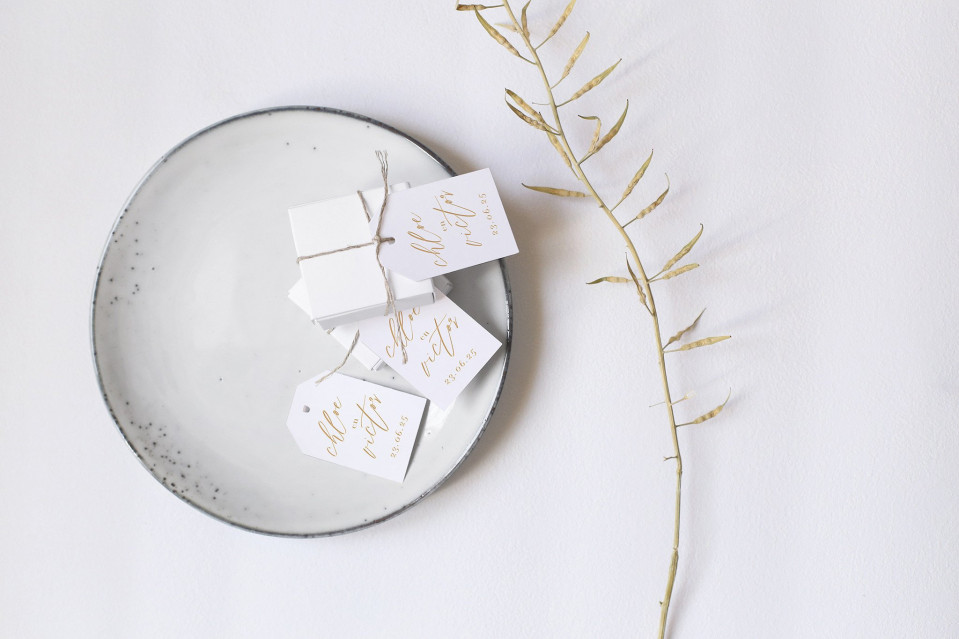 gouden bladeren op een bord met witte papieren labels
