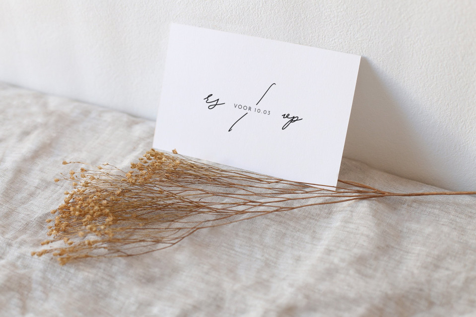 een ansichtkaart met een boeket gedroogde bloemen op een bed