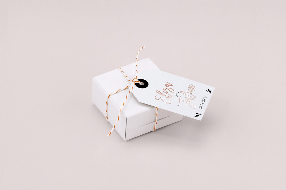 een witte cadeaubox met een label eraan gebonden