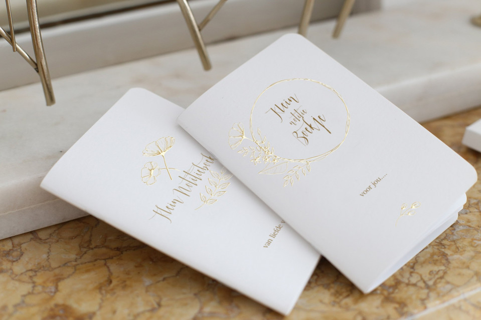 twee witte trouwkaarten met gouden folie letters