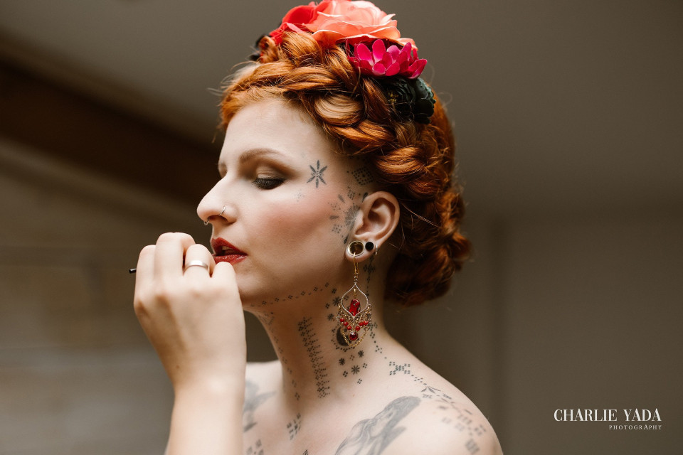 een vrouw met tatoeages op haar gezicht en een bloem in haar haar