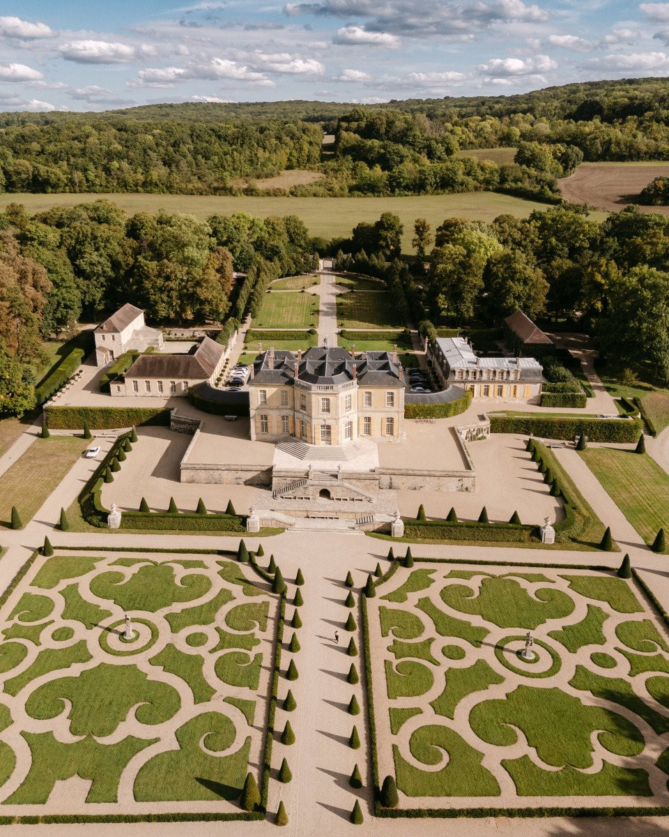 een luchtfoto van een groot landhuis in het midden van een veld