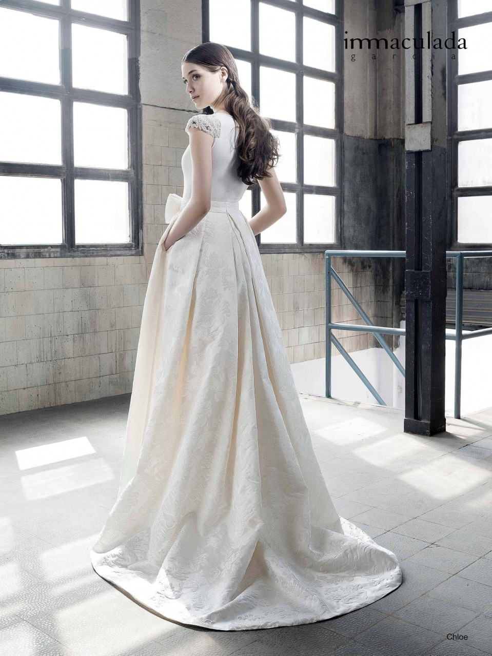 een vrouw in een trouwjurk die in een lege kamer staat