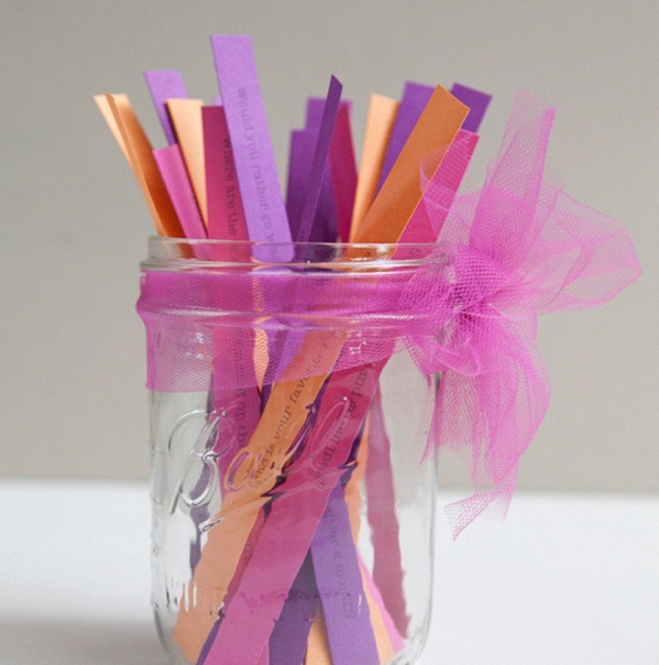 een pot gevuld met kleurrijke papieren stokjes