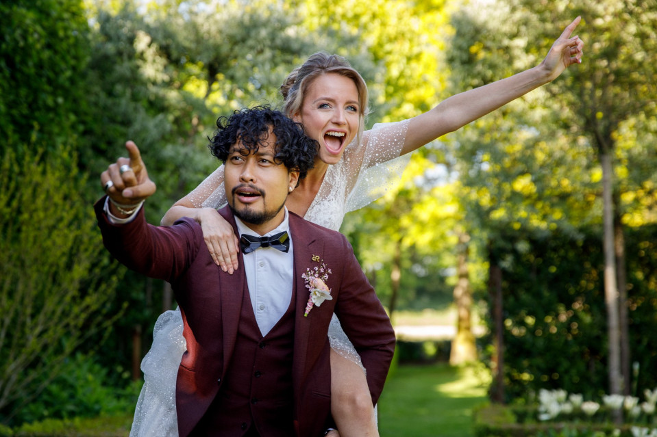 een bruid en bruidegom poseren voor een foto in de tuin