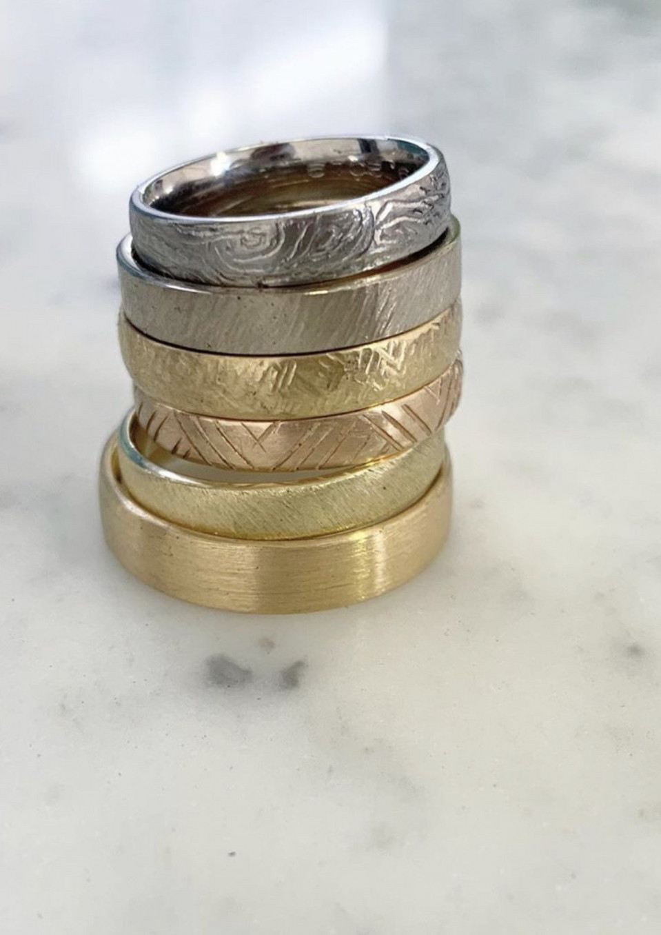 vier verschillend gekleurde trouwringen op elkaar gestapeld