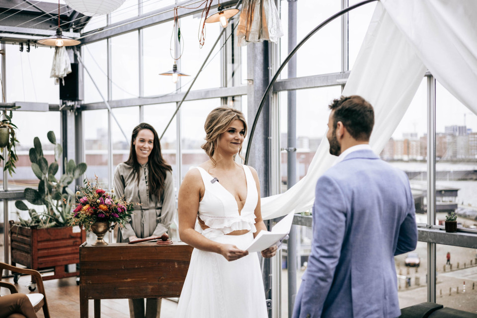 de bruid en bruidegom wisselen geloften uit in de daktuin