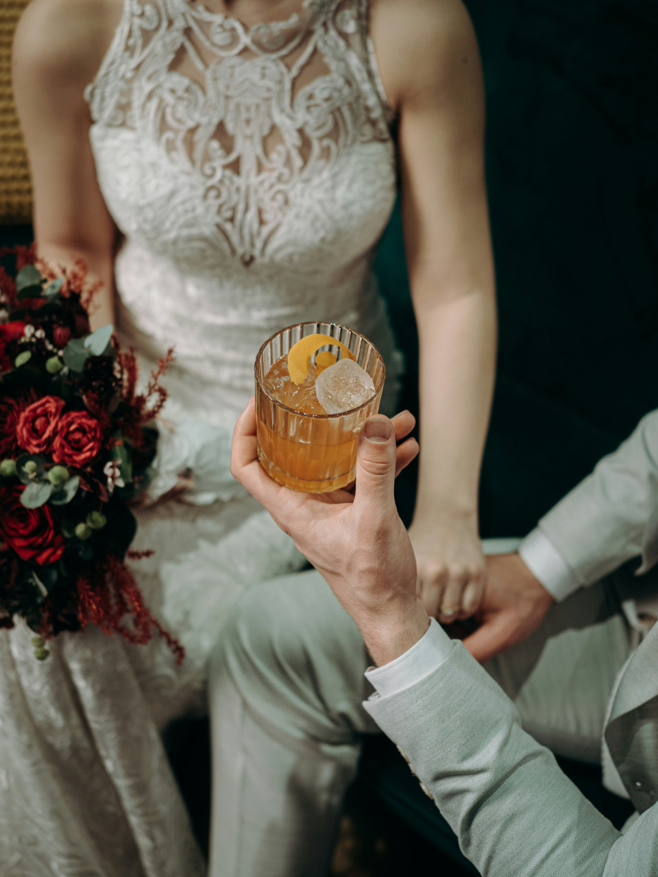 een bruid en bruidegom die een cocktailglas vasthouden