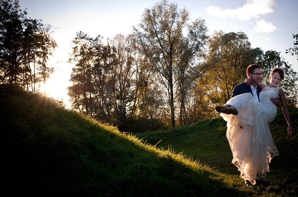 een bruid en bruidegom houden elkaar vast in het gras