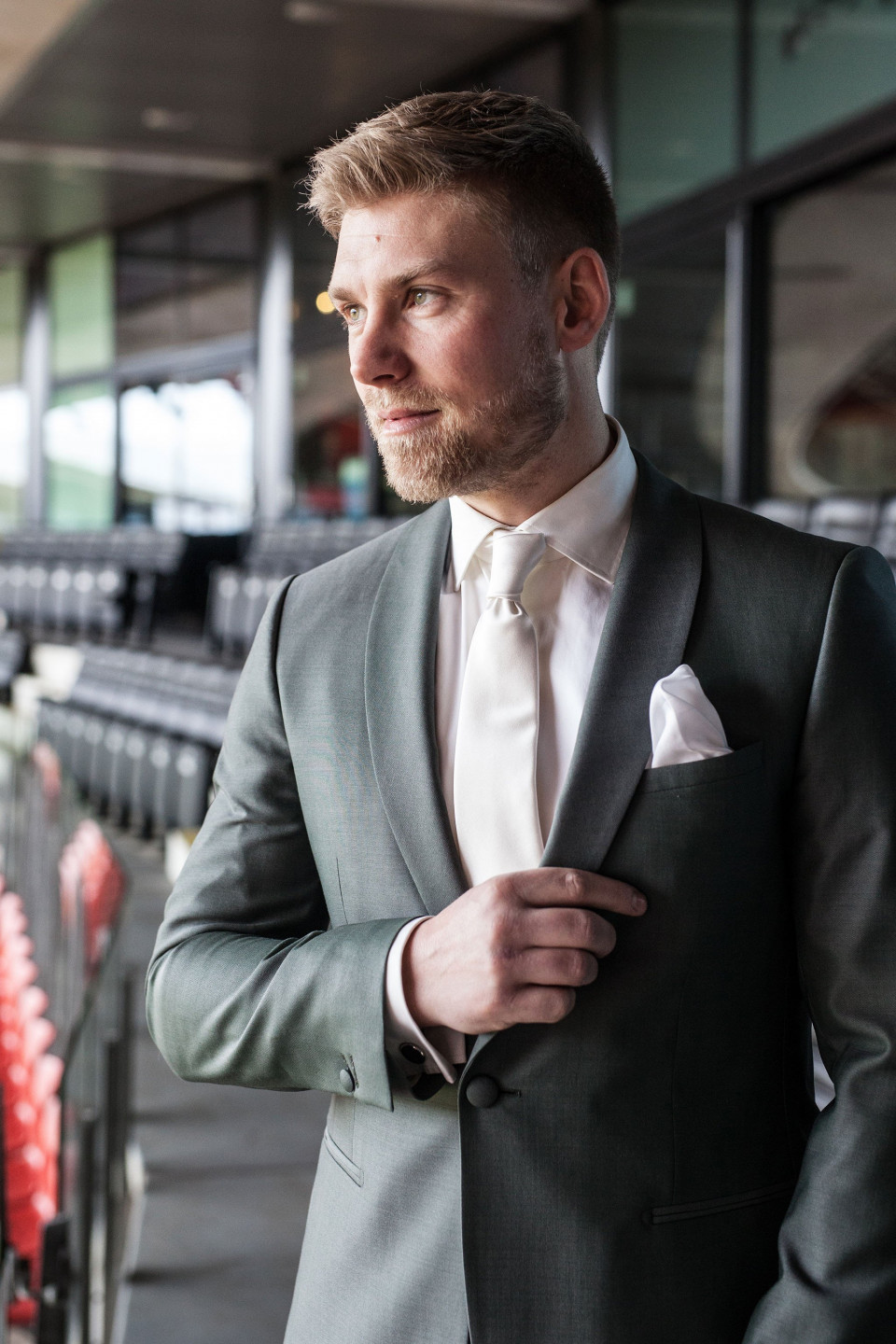 een man in een pak en stropdas staande in een stadion