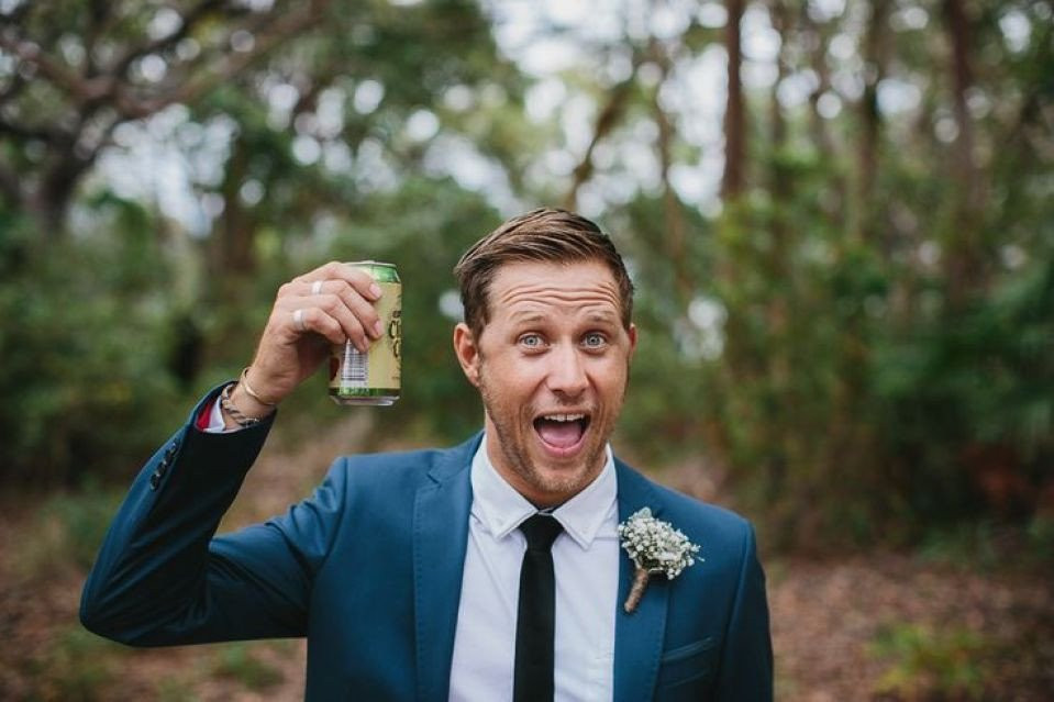 een man in een pak die een fles bier vasthoudt