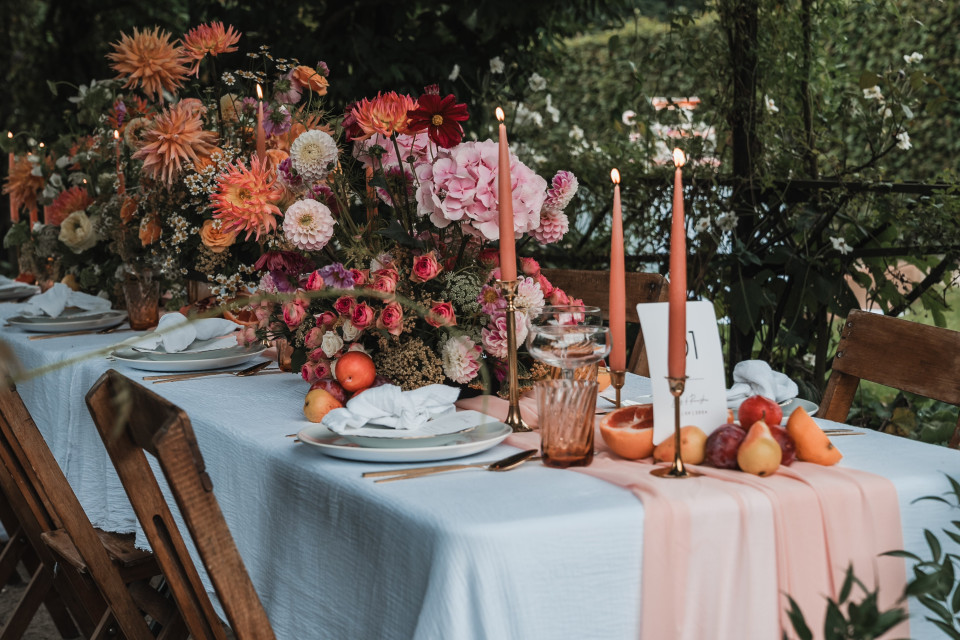 een tafel gedekt voor een huwelijksreceptie met bloemen en kaarsen