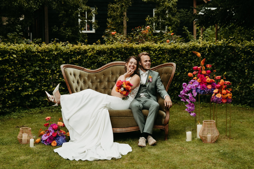 een man en een vrouw die op een bank in het gras zitten