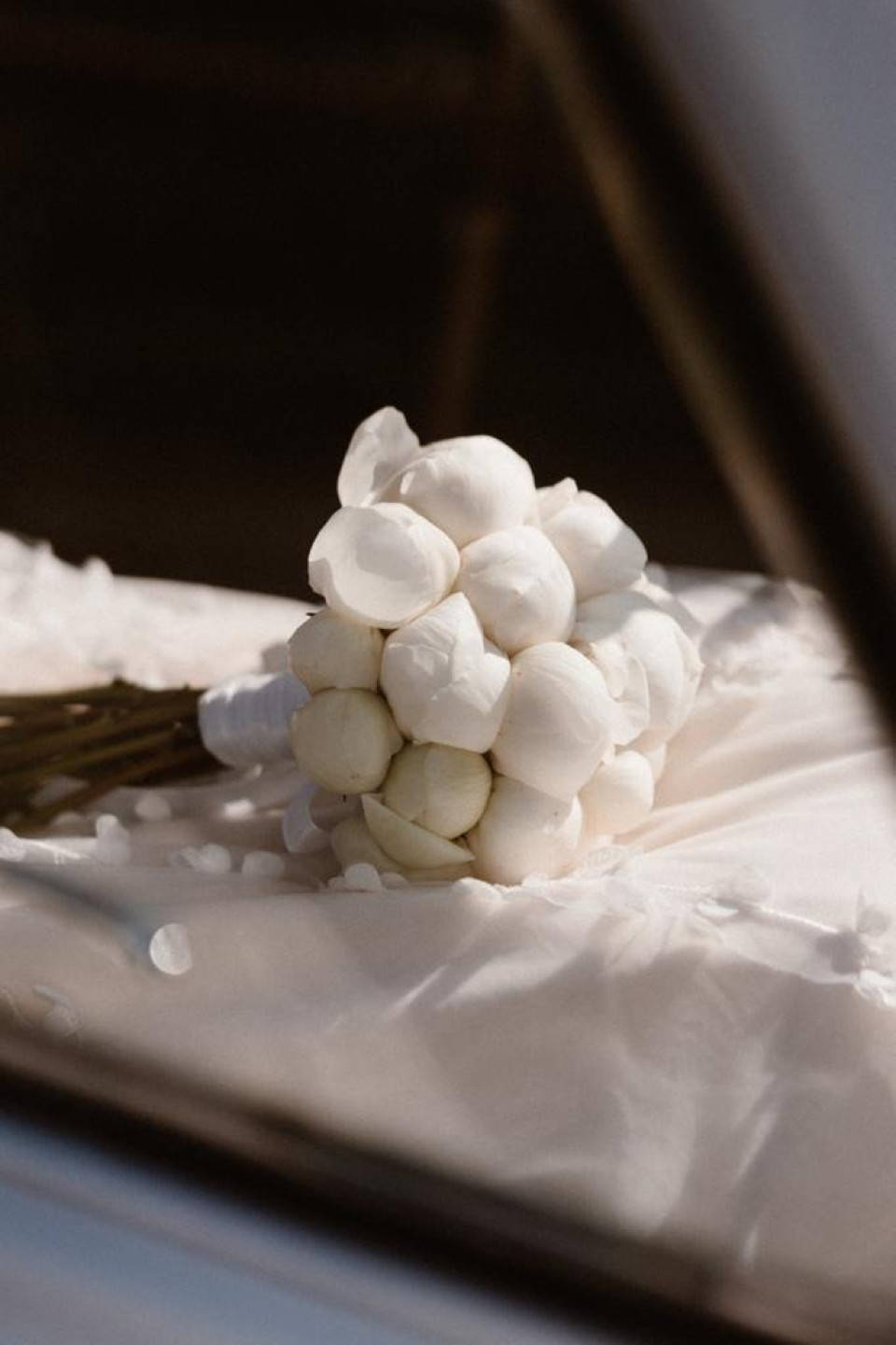 een boeket witte bloemen in een autoraam