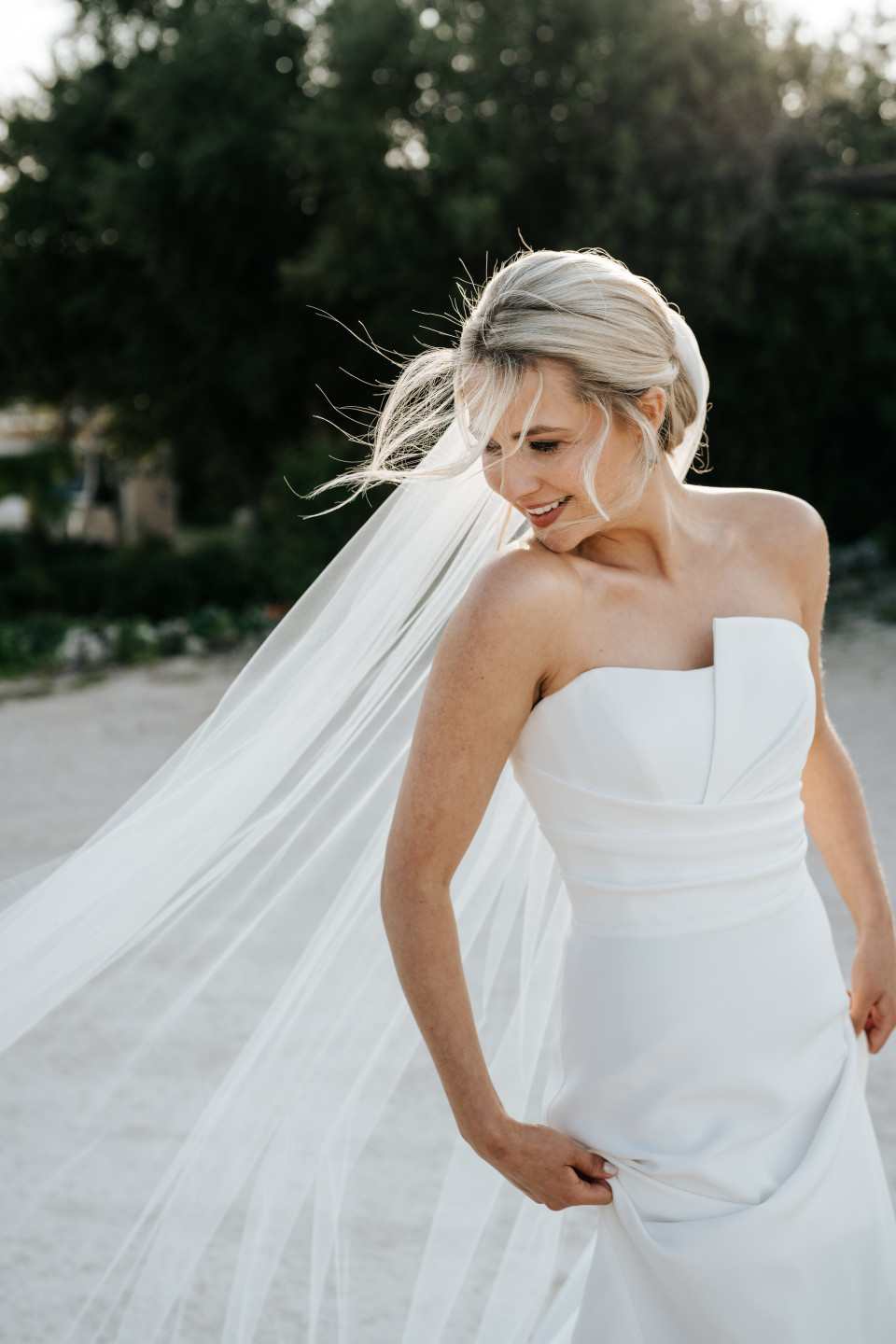 een bruid in een witte jurk en sluier