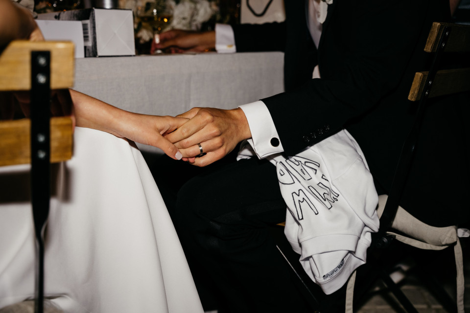 een bruid en bruidegom die elkaars handen vasthouden op een bruiloftsreceptie