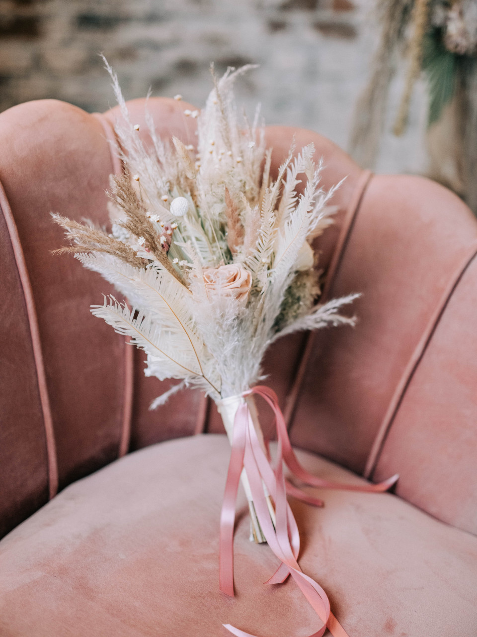 roze fluwelen stoel met een boeket roze bloemen