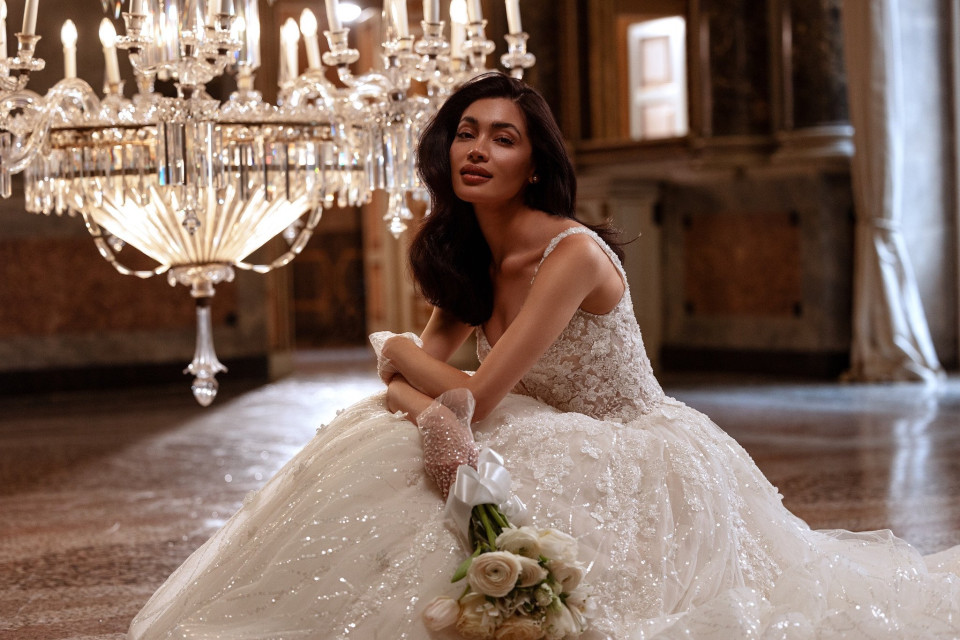 een vrouw in een trouwjurk die op de vloer zit