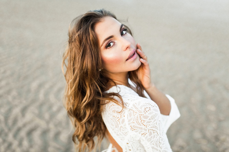 een mooie jonge vrouw in een witte jurk op het strand