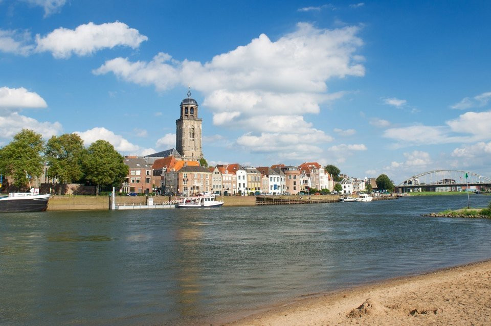 een rivier met een kerk en gebouwen aan de oever