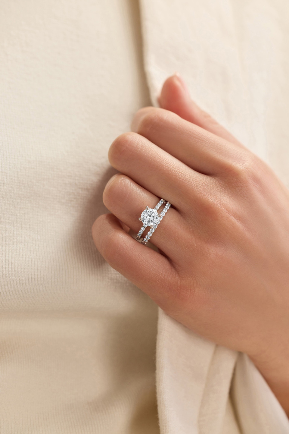 de hand van een vrouw die een diamanten verlovingsring vasthoudt
