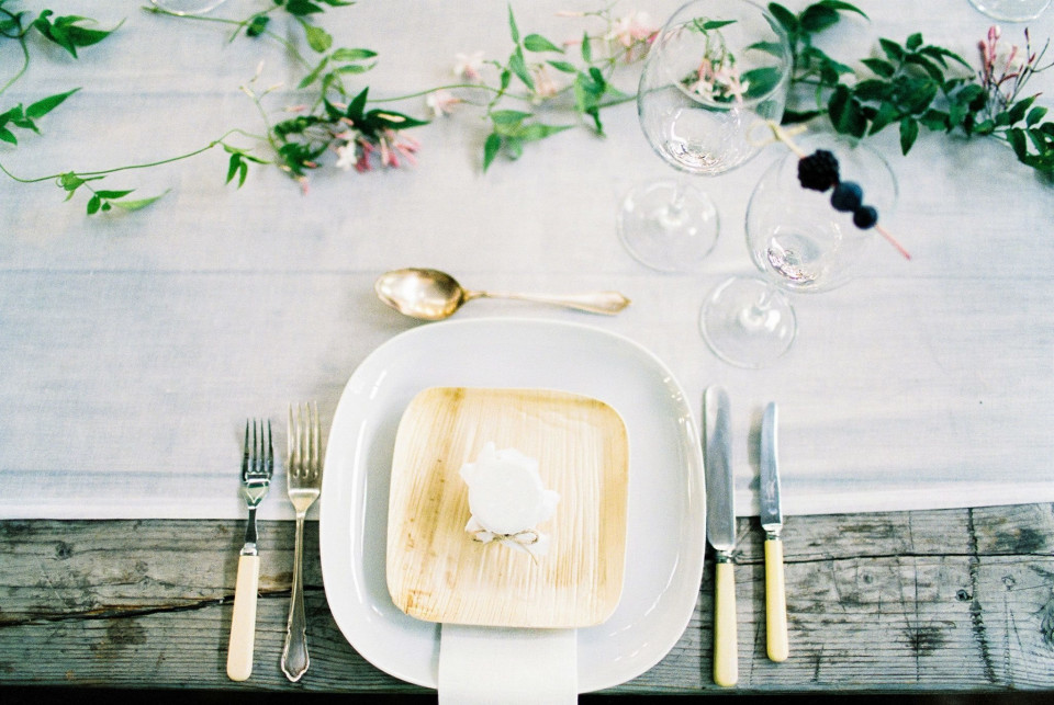 een wit bord met een houten plank en bestek