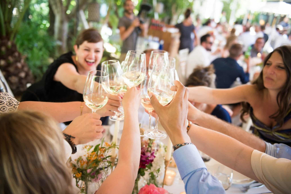 een groep mensen proosten met wijnglazen