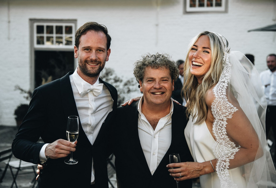 een bruid en bruidegom poseren met hun ouders