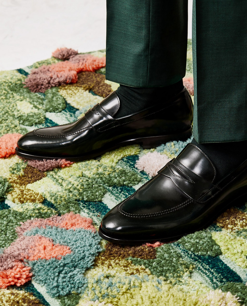een man met zwarte schoenen op een kleurrijk tapijt