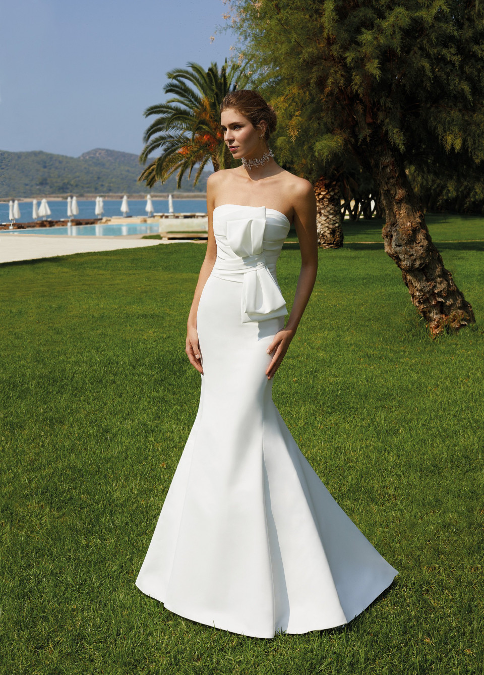 een vrouw in een strapless trouwjurk staande op het gras