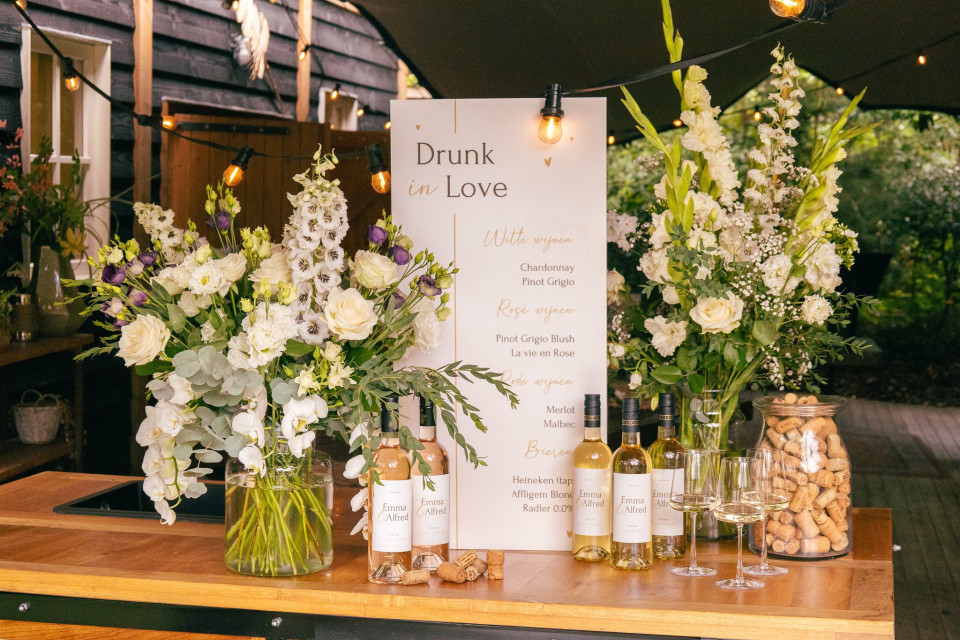 een bos bloemen en flessen wijn op een tafel