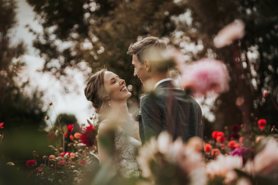 een man en een vrouw die in een veld met bloemen staan
