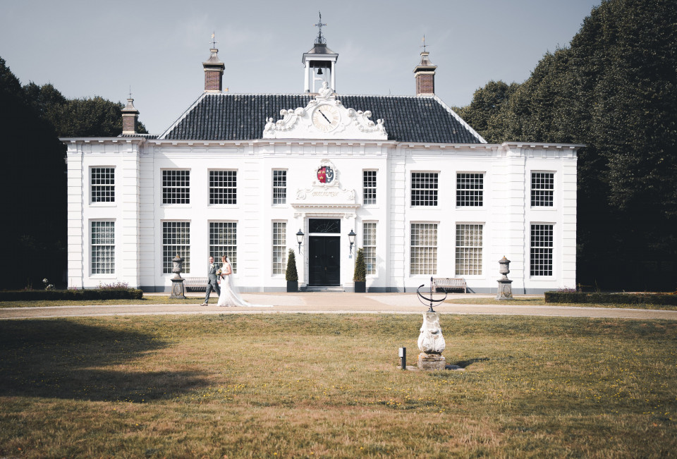 een wit huis met een standbeeld ervoor