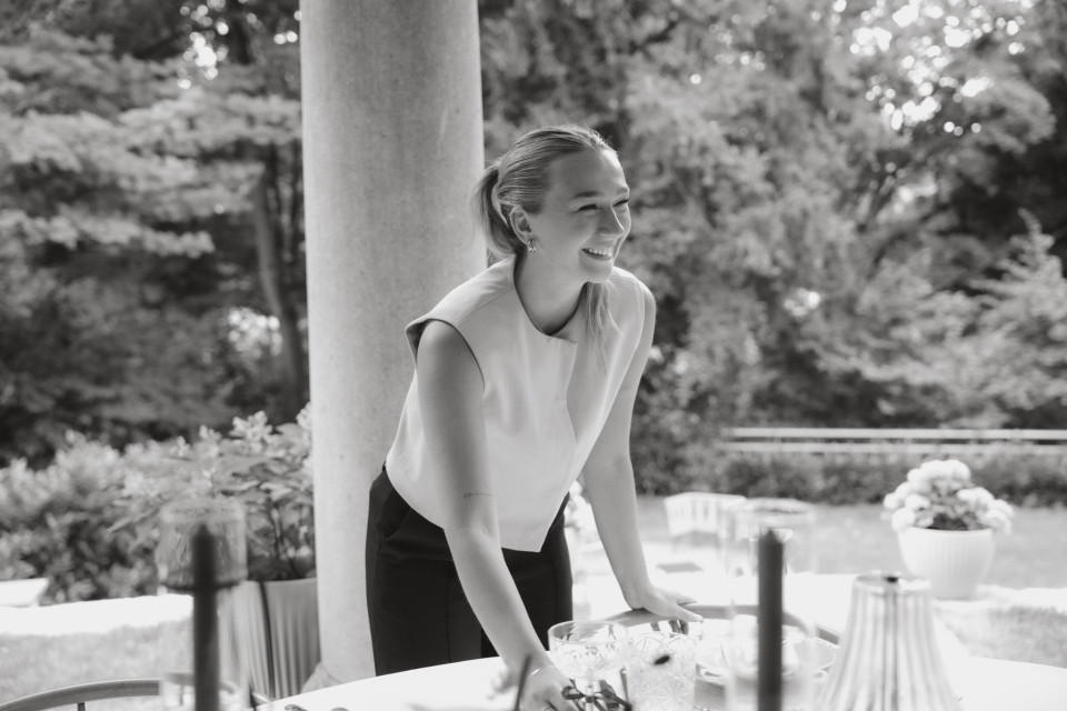 een zwart-wit foto van een vrouw die een taart snijdt