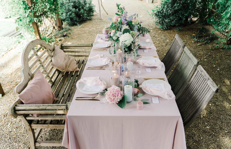 een tafel gedekt voor een bruiloftsreceptie met roze en witte bloemen