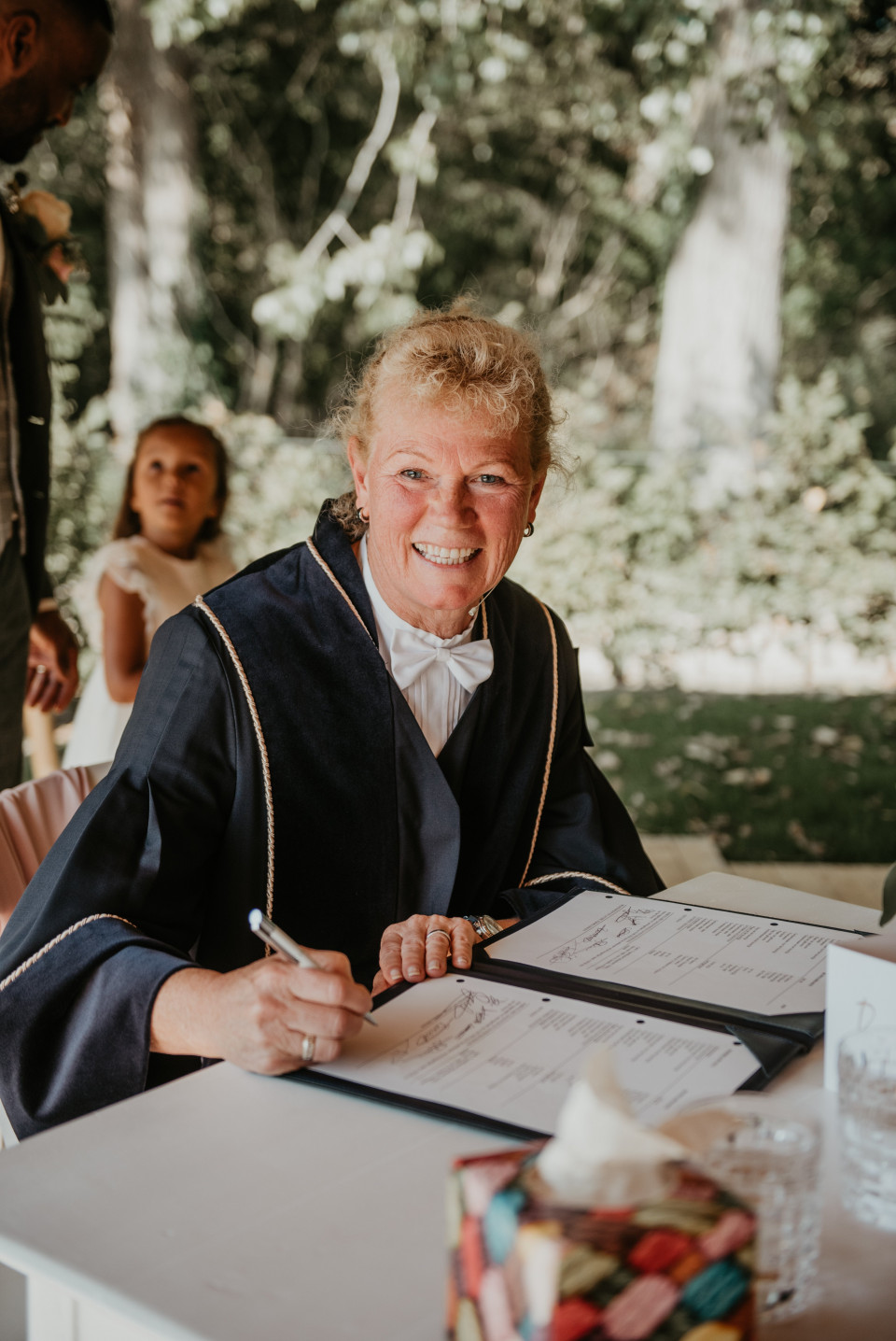 een vrouw in een trouwjurk die een document ondertekent