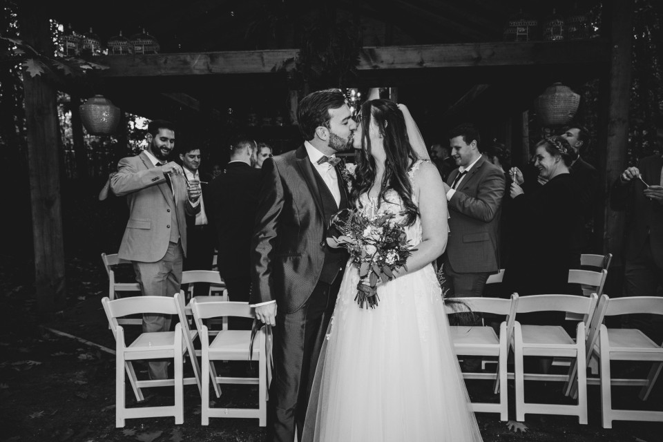 de bruid en bruidegom die aan het einde van het gangpad kussen