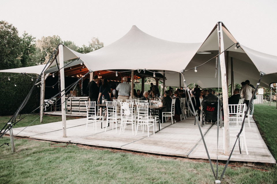 een tent met tafels en stoelen opgesteld buiten
